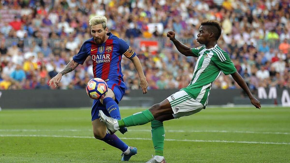 Lionel Messi (izq.), del Barcelona, disputa el balón con Charly Musonda, del Betis, en la Liga Española, en el Camp Nou en Barcelona, España, el sábado 20 de agosto del 2016.