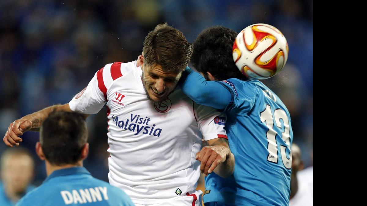 
El jugador del Sevilla Carriço (c) salta a por un balón con Luis Neto (d), del Zenit de San Petersburgo, durante el partido de vuelta de los cuartos de final de la Liga Europa disputado esta noche en el estadio Petrovsky de San Petersburgo, en Rusia, hoy 23 de abril de 2015.
