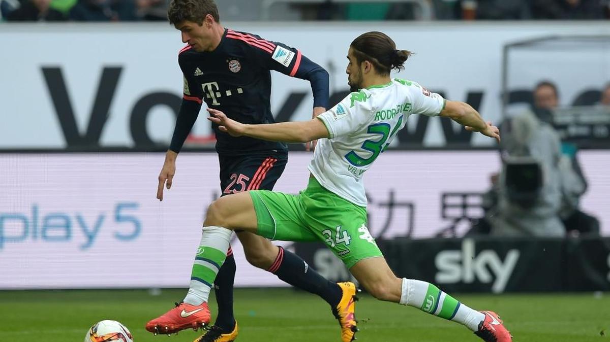 El lateral suizo del Wolfsburgo Ricardo Rodríguez trata de impedir el avance de Thomas Müller, del Bayern Munich.