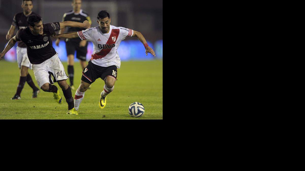 
Ariel Rojas (der.), de River Plate, lucha por la bola con Gustavo Gomez, del Lanús, el domingo en Buenos Aires.
