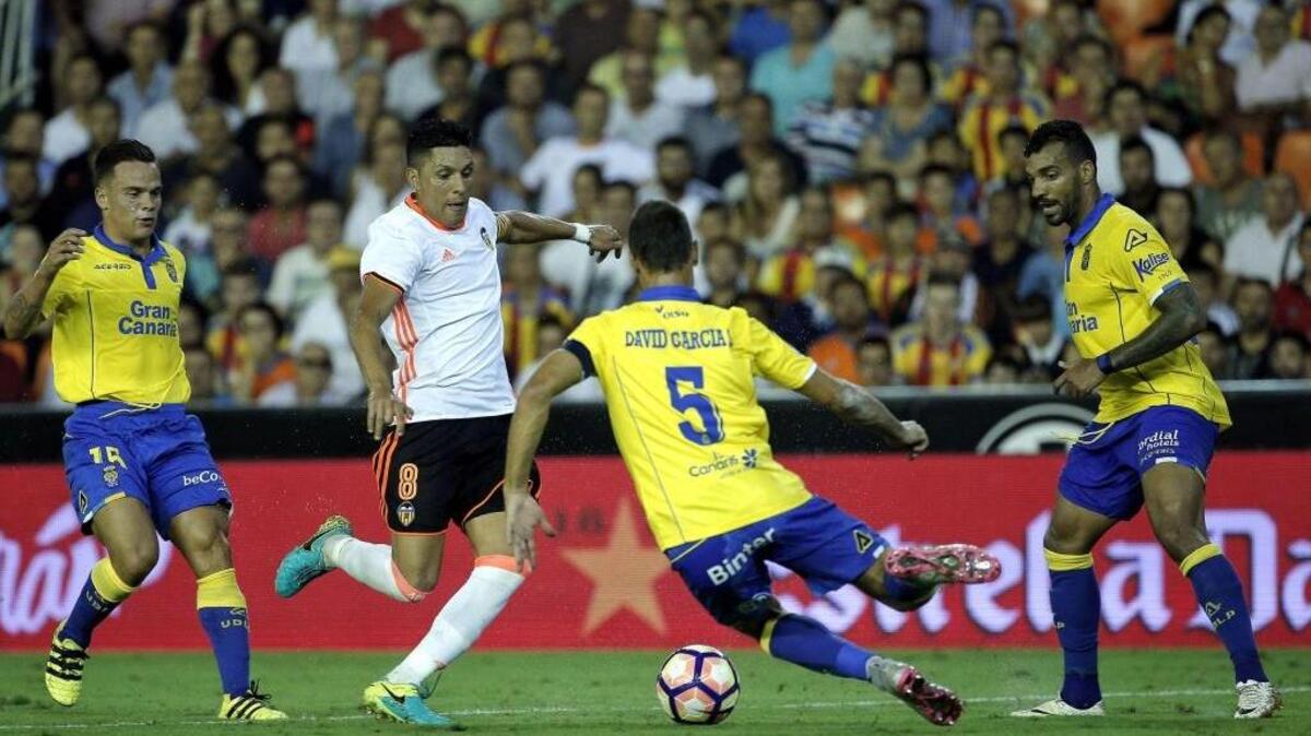 El centrocampista argentino del Valencia CF, Enzo Pérez (2do izq.), le disputa el balón a David García (#5), de la UD Las Palmas, el lunes en el estadio Mestalla, en Valencia.