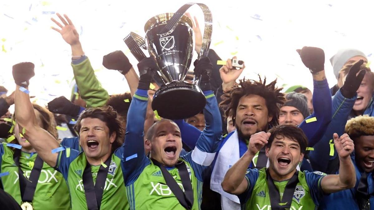 El paraguayo Nelson Valdez, el cubano Osvaldo Alonso (con la Copa), el panameño Román Torres y el uruguayo Nicolás Lodeiro celebran el título de los Sounders de Seattle sobre Toronto, en la final en Toronto, la noche del sábado 10 de diciembre del 2016.