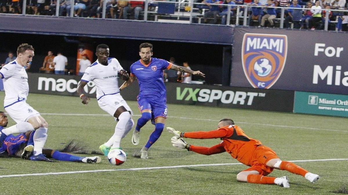 Stefano Pinho, desde el suelo y Vincenzo Rennella (der.), del Miami FC, tratan de anotar contra el FC Edmonton, el 29 de abril en el Riccardo Silva Stadium.