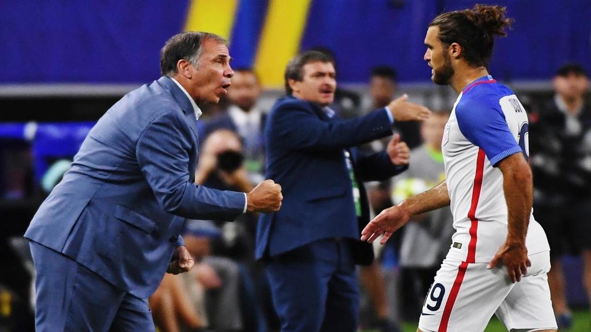 El entrenador de Estados Unidos Bruce Arena hace indicaciones de manera enérgica a Graham Zusi (19), en el triunfo sobre El Salvador en las semifinales de la Copa de Oro de la CONCACAF, en Arlington, Texas, la noche del sábado 22 de julio del 2017.