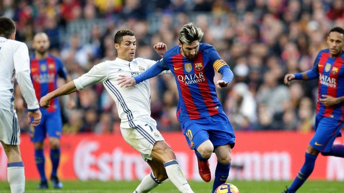 El delantero de Barcelona Lionel Messi (centro) se lleva el balón marcado por Cristiano Ronaldo, del Real Madrid, en el Camp Nou, el 3 de diciembre del 2016.