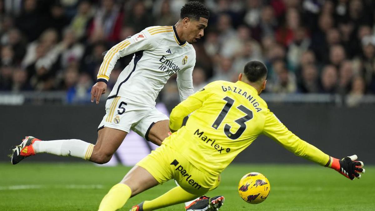Jude Bellingham (izq.) supera al portero del Girona (13) y anota el primero autor de sus dos goles con el Real Madrid en su triunfo 4-0 por la liga, este sábado 10 de febrero en el estadio Santiago Bernabéu en Madrid, España.