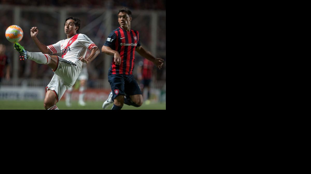
Leonardo Pisculichi, de River Plate, controla el balón ante Matías Caruzzo, de San Lorenzo.


