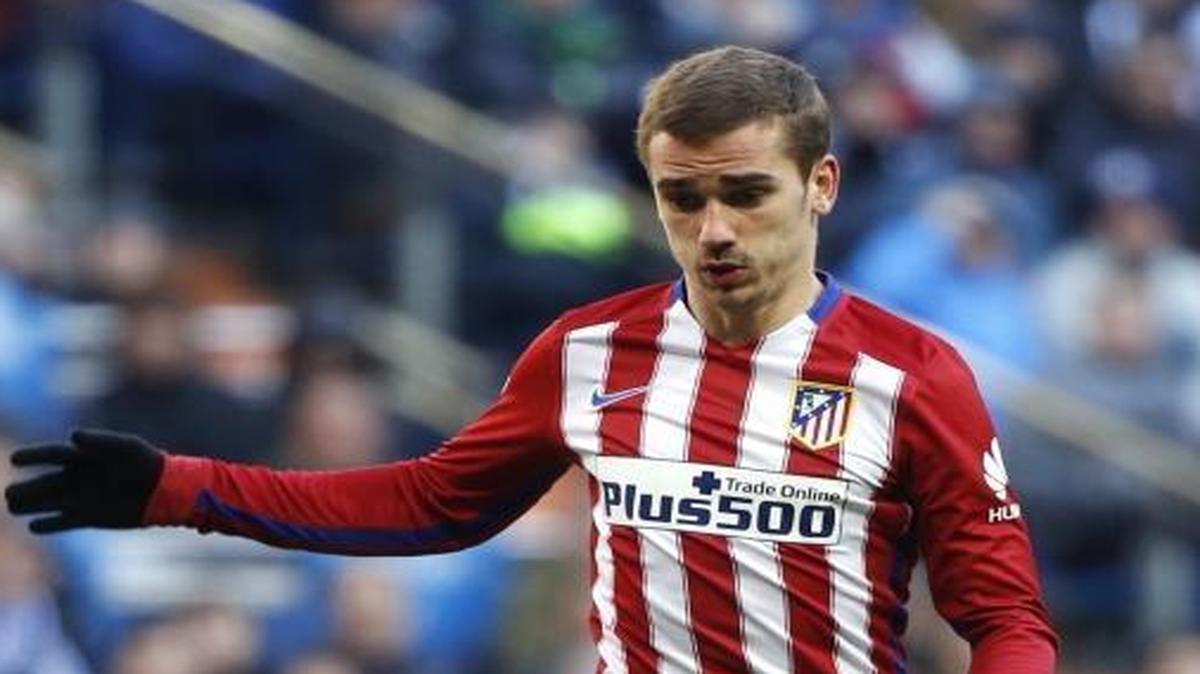 El delantero francés del Atlético de Madrid Antoine Griezmann (der.) se dispone a conseguir el gol de la victoria sin que el defensa del Real Madrid Dani Carvajal (izq.) pueda impedirlo.