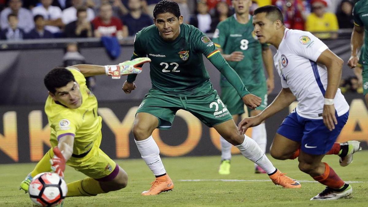 El arquero de Bolivia Carlos Lampe salva ante la presión del chileno Alexis Sánchez (der.) y la mirada del boliviano Edward Zenteno (22), en Copa América Grupo D, el viernes 10 de junio del 10, 2016, rn Foxborough, Mass.