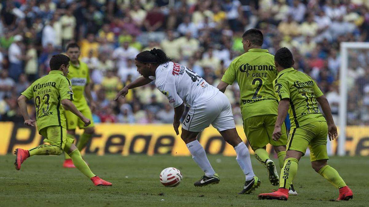 
El jugador brasileño del Querétaro Ronaldinho (centro) trata de desmarcarse de tres jugadores de América en el partido efectuado el 18 de abril del 2015 en Ciudad de México.


