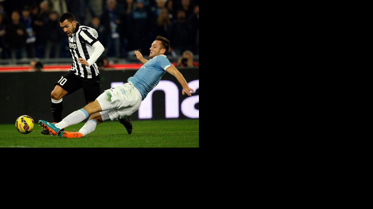 
El argentino Carlos Tevez, quien volvió a marcar para la Juve, se escapa del jugador de la Lazio Stefan De Vrij.


