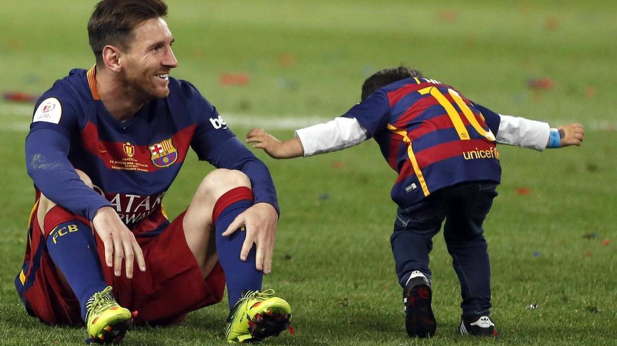 El delantero del FC Barcelona Leo Messi (i) celebra con su hijo tras vencer al Sevilla en la final de la Copa del Rey disputada esta noche en el estadio Vicente Calderón, en Madrid.