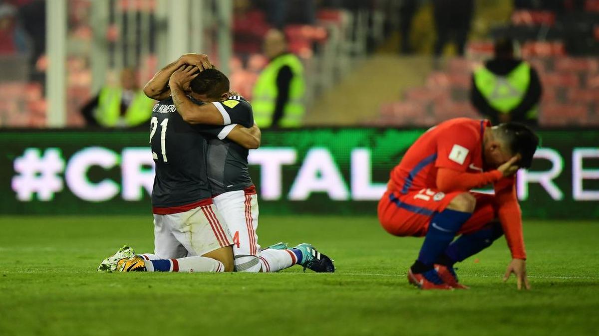 Los jugadores de Paraguay Richard Ortíz y Oscar Romero (izq.) celebran y el defensa de Chile Gary Medel (der.) en el triunfo guaraní 3-0 en Santiago.