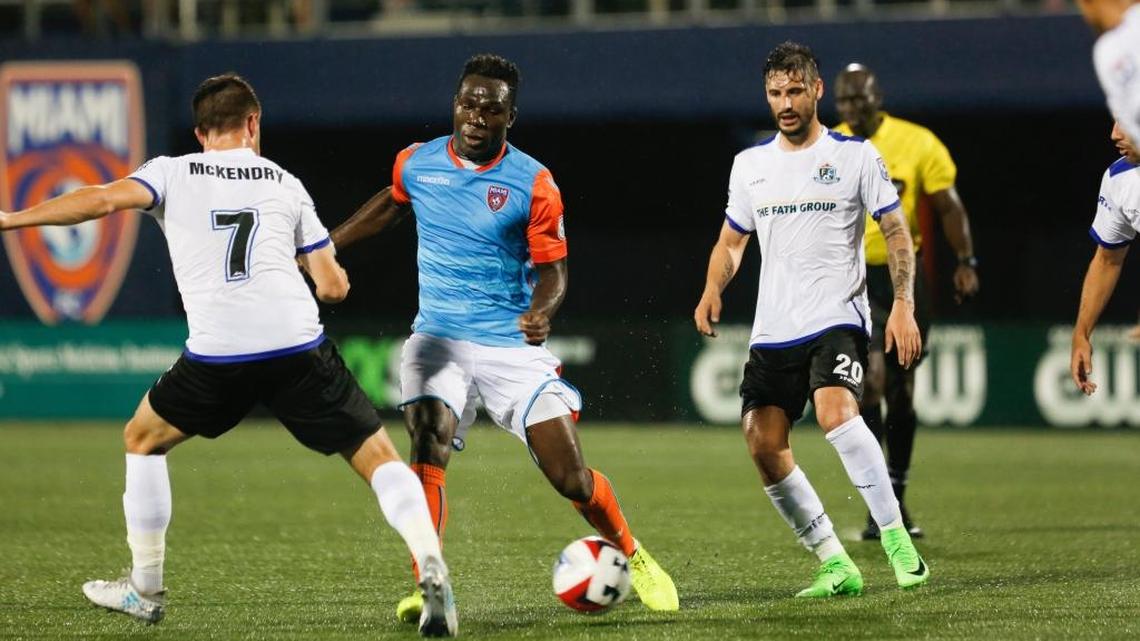 El ghanés Kwadwo, del Miami FC, enfrenta a Ben McKendry (7) y Nicolas di Biase (20), del FC Edmonton, la noche del sábado 28 de octubre del 2017 en el Riccardo Silva Stadium (FIU) en Miami.