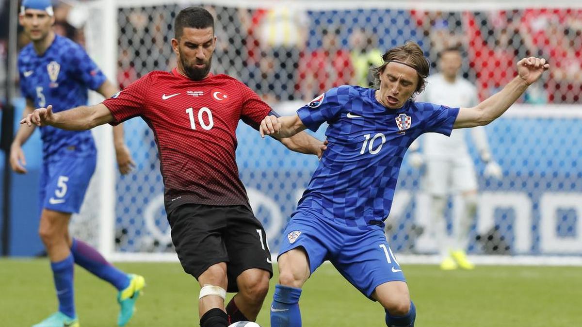 El jugador de Croacia Luka Modric (der.) disputa el balón con Arda Turan, de Turquía, en un partido de la Eurocopa, el 12 de junio de 2016 en París.