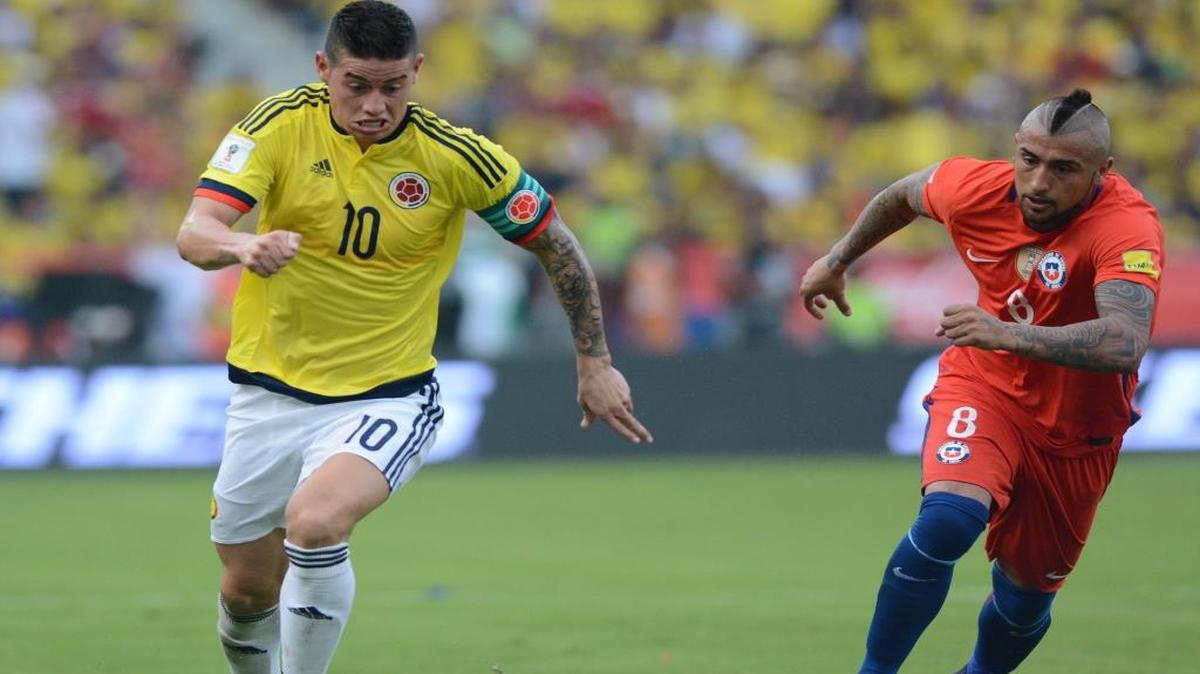 El capitán de Colombia James Rodríguez (izq.), conduce el balón el 10 de noviembre del 2016, ante el jugador de Chile Arturo Vidal, con quien compartirá vestuario en el Bayern Munich.