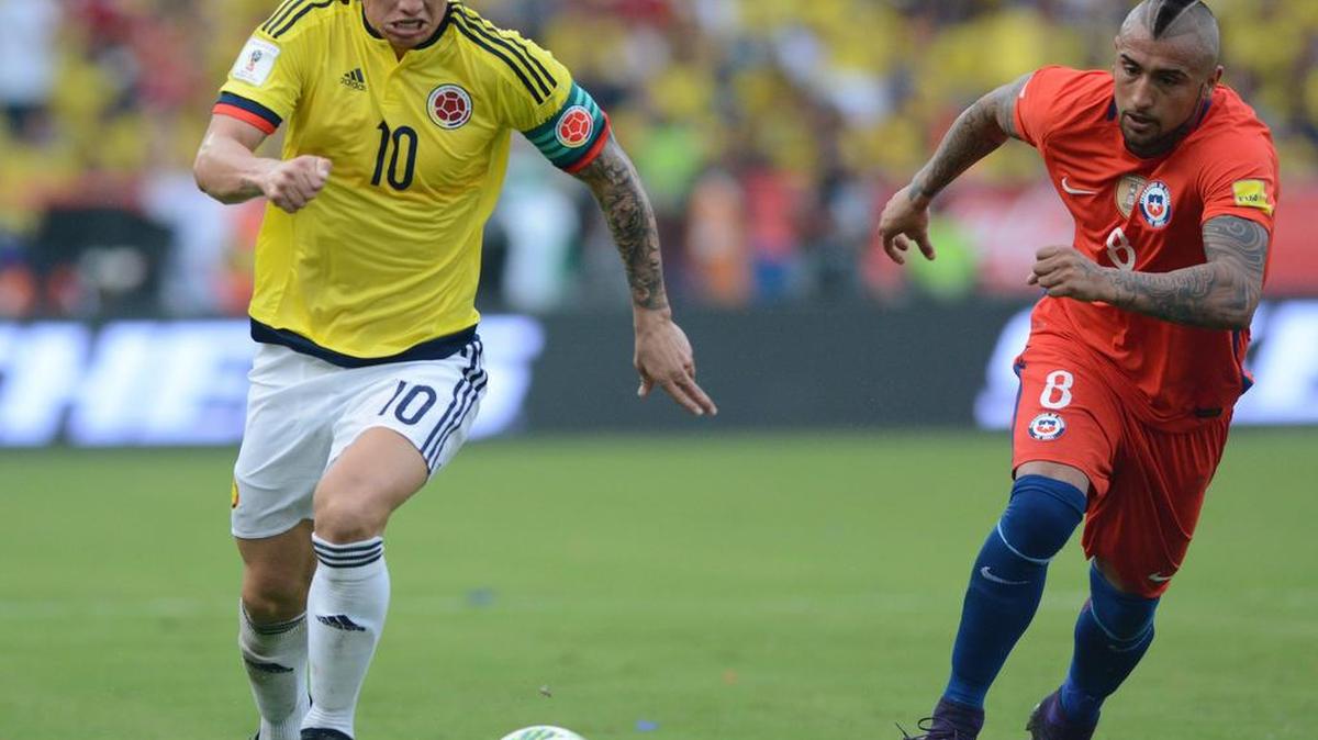 James Rodríguez, de Colombia, se escapa con la bola perseguido por Arturo Vidal, de Chile, en un choque por las eliminatorias en noviembre pasado.