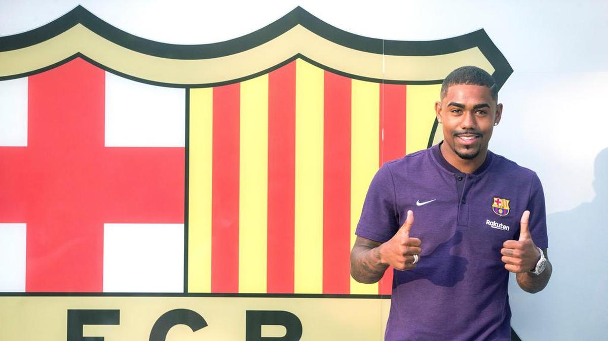 GRAF6319. BARCELONA, 24/07/2018.- El futbolista brasileño Malcom Filipe Silva de Oliveira posa para los medios de comunicación junto al escudo azulgrana tras anunciarse su fichaje por cinco temporadas por el FC Barcelona. EFE/Quique García