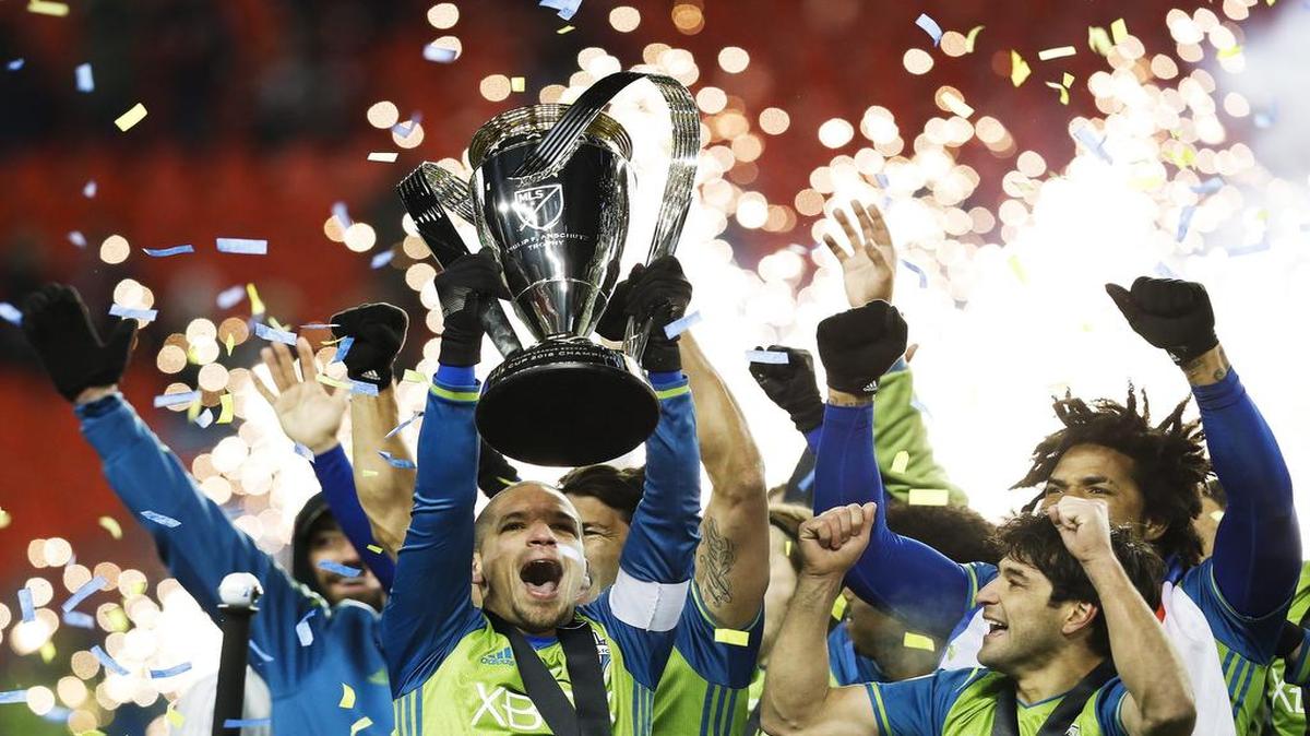 El mediocampista cubano Osvaldo Alonso (izq.) levanta la copa de campeón de la MLS que ganó su equipo, el Sounder de Seattle, tras vencer 5-4 a Toronto en la tanda de penales, el sábado 10 de diciembre del 2016.