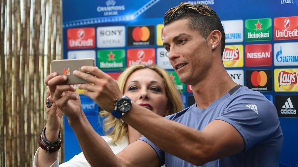 El delantero portugués del Real Madrid, Cristiano Ronaldo se toma un selfie con una periodista en la zona mixta de Valdebebas Sport City, en Madrid, el 30 de mayo de 2017 en el evento del Día de los Medios antes de la Juventus vs Real Madrid.