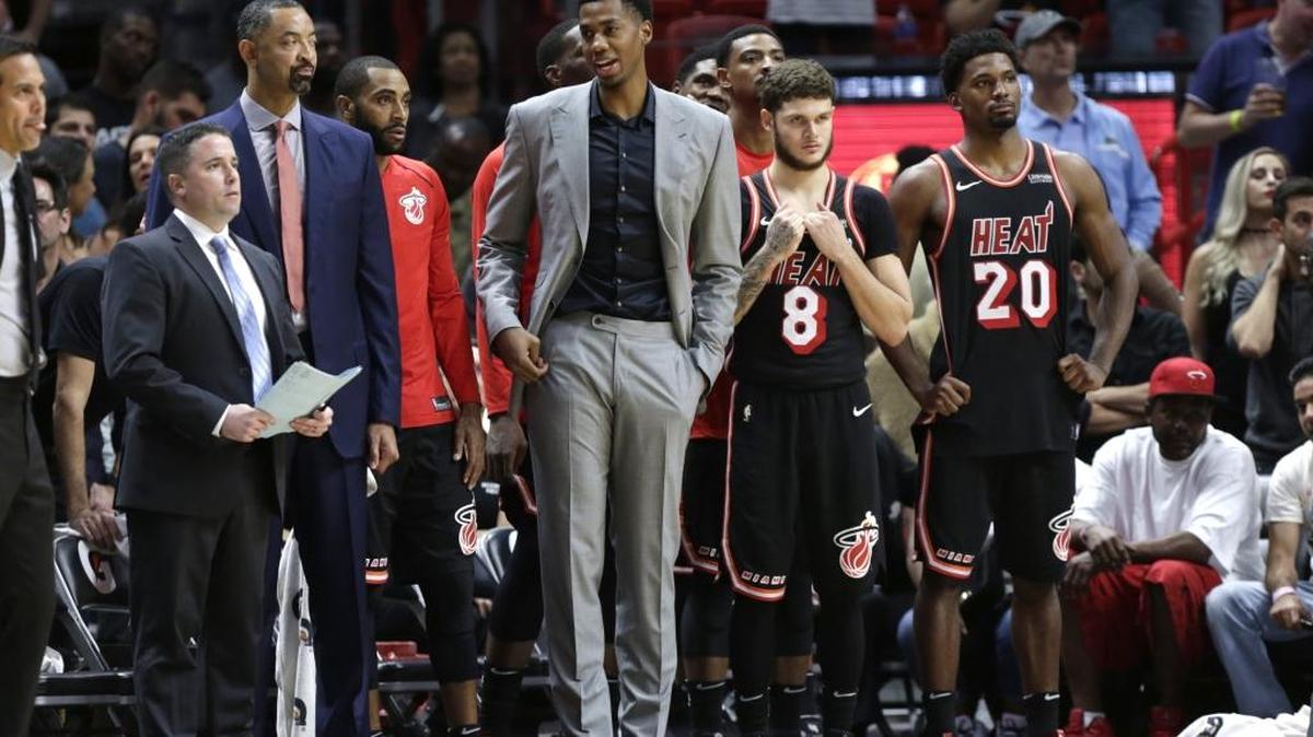 Los jugadores del Heat Hassan Whiteside (centro), Tyler Johnson (8) y Justise Winslow (20) en la banca miran el juego ante los Hornets el 1 de diciembre en el American Airlines Arena.