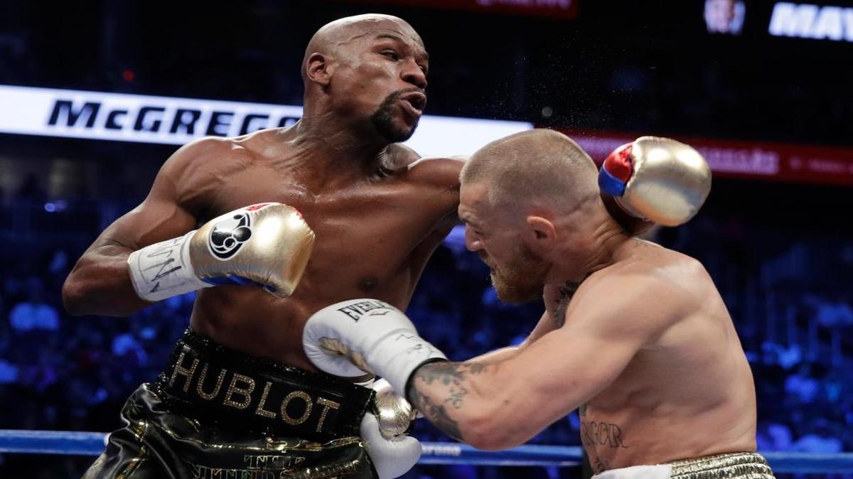 FLOYD MAYWEATHER (izq.) ataca a Conor McGregor en la pelea del 26 de agosto del 2017 en Las Vegas.