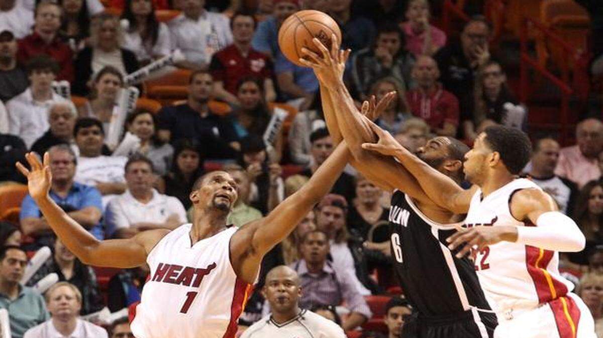 
Los jugadores del Heat Chris Bosh (izq.) y Danny Granger (der.) tratan de bloquear el tiro de Alan Anderson, de los Nets de Brooklyn, en el partido efectuado el 4 de enero en Miami.


