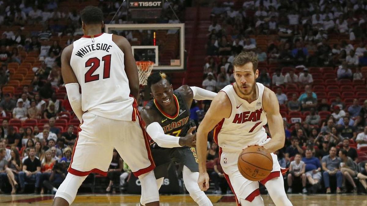 El armador del Heat Goran Dragic (der.) aprovecha la pantalla que le hace el centro de Miami Hassan Whiteside (#21) para dejar atrás al defensa de los Hawks Dennis Schroder, en un partido de pretemporada el pasado 1 de octubre en el American Airlines Arena.