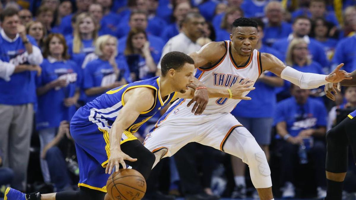 El armador de los Warriors Stephen Curry (izq.) trata de evadir la marca de Russell Westbrook, del Thunder, el 22 de mayo en el Juego 3 en Oklahoma City.
