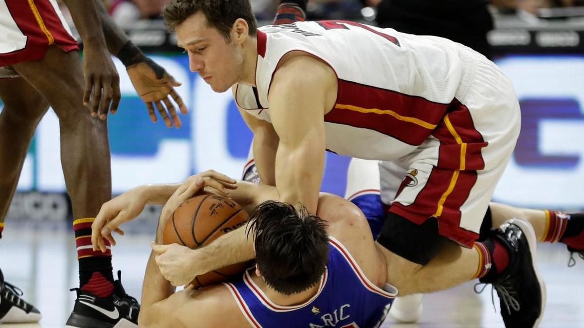 Goran Dragic (arriba), del Heat, lucha por el balón con Dario Saric, de los Sixers, el sábado en Filadelfia.