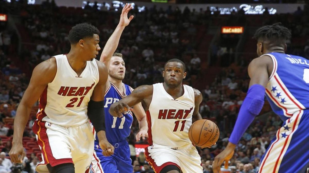 Dion Waiters (11), del Heat, escoltado por Hassan Whiteside (21) se escurre entre los los 76ers, la noche del sábado en Miami.