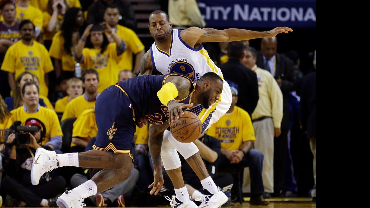 
El astro de los Cavaliers LeBron James (izq.) patina ante el jugador de los Warriors Andre Iguodala.
