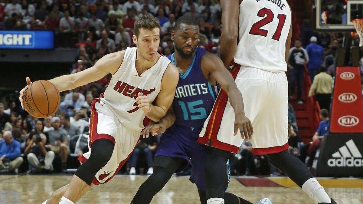 Goran Dragic (7), del Heat, elude a Kemba Walker (15), de los Hornets, con la ayuda de Hassan Whiteside, en la AmericanAirlines Arena, la noche del viernes 28 de octubre del 2016.