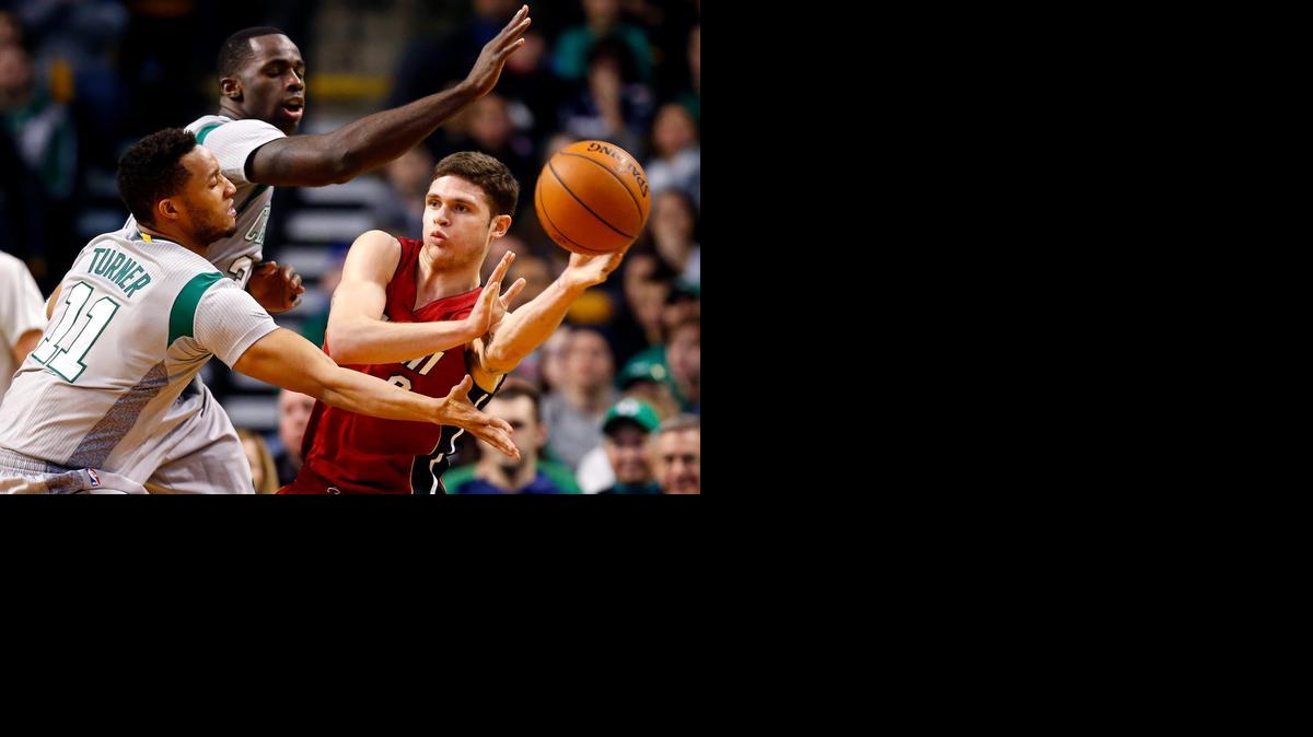 
Tyler Johnson intenta pasar sobre Evan Turner (11) y Brandon Bass, de los Celtics, el domingo.
