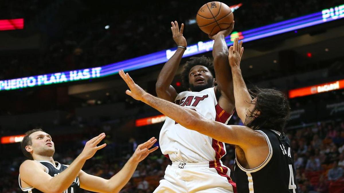 Justise Winslow tira al aro ante la marca de los jugadores de los Nets Bojan Bogdanovic (izq.) y Luis Scola, en el partido efectuado el 11 de octubre del 2016 en Miami.