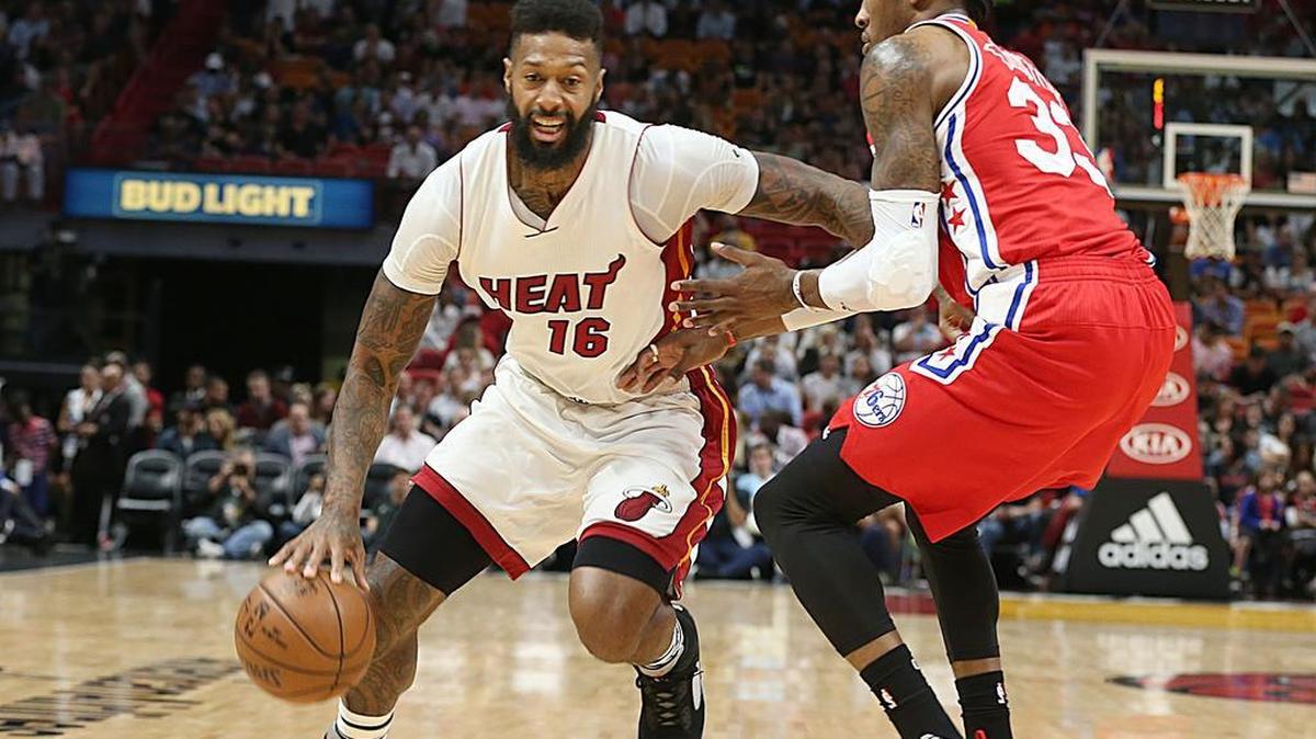 El jugador del Heat James Johnson (izq.) conduce la pelota ante la marca de Robert Covington, de los 76ers, el 1ro de marzo del 2017 en Miami.