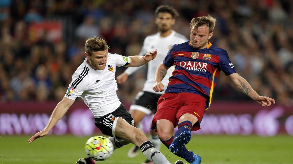 El mediocampista de Barcelona Ivan Rakitic (der.) disputa el balón con Shkodran Mustafi, del Valencia, en el partido de la liga española, celebrado el 17 de abril del 2016 en Barcelona.