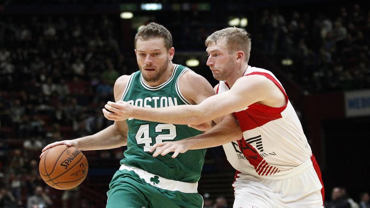 
El jugador de los Celtics David Lee (izq.) conduce la pelota ante la marca de Robbie Hummel, del Olimpia Milano, durante un partido amistoso el 6 de agosto del 2015 en Milán, Italia.
