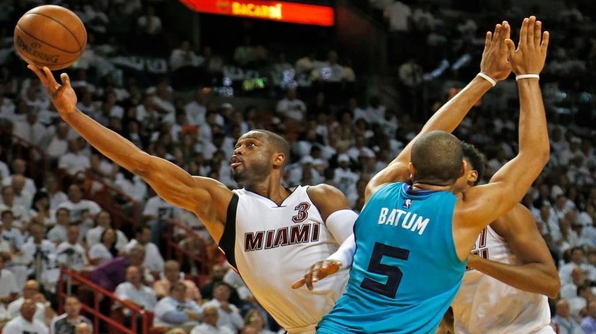 El escolta del Heat Dwyane Wade (izq.) trata de anotar la canasta ante la marca de Nicolas Batum, de los Hornets, en el segundo juego del playoff, el 20 de abril del 2016 en Miami.