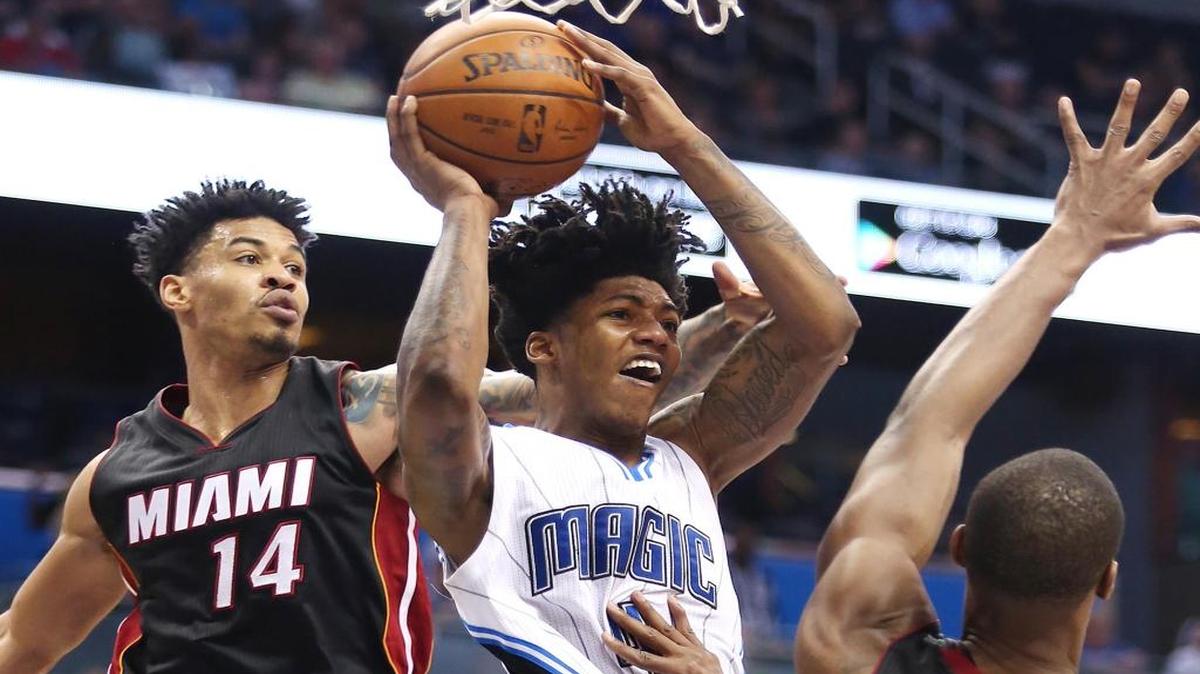El escolta del Magic Elfrid Payton (centro) trata de pasar el balón ante la marca de Chris Bosh (izq.) y Gerald Green, del Heat, el sábado 26 de diciembre del 2015 en Orlando.