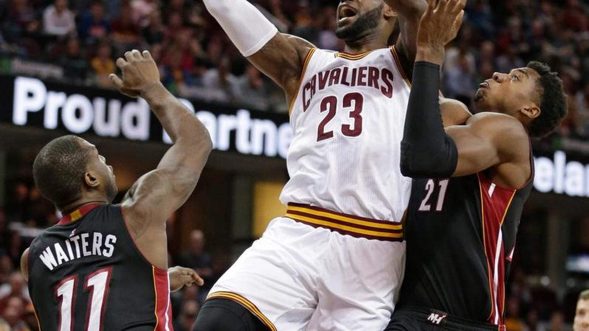 LeBron James, de los Cavs (23), entra al aro entre los jugadores del Heat Dion Waiters (11) y Hassan Whiteside (21), el 6 de marzo del 2017 en Cleveland.