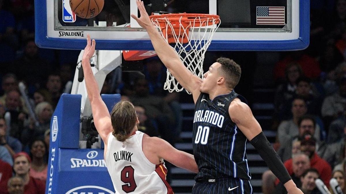 Kelly Olynyk, del Heat (9), tira al aro al tiempo que Aaron Gordon, el mejor del Magic con 39 puntos (00), trata de que no anote este sábado en Orlando.