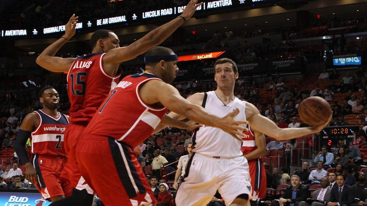 El armador del Heat Goran Dragic se dispone a pasar la bola marcado por Jared Dudley (centro) y Ryan Hollins (der.), de los Wizards de Washington, en el segundo cuarto, la noche del lunes 7 de diciembre del 2015.