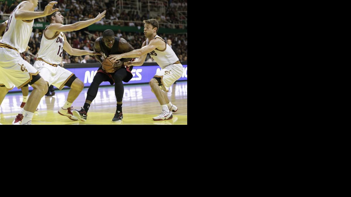 
El jugador del Heat James Ennis (centro) trata de burlar la defensa de tres jugadores de los Cavaliers, el sábado 11 de octubre en Río de Janeiro.


