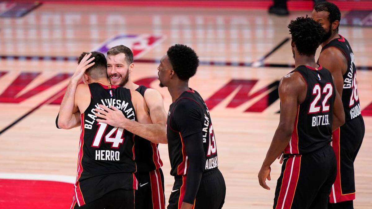 El armador del Heat Goran Dragic abraza a Tyler Herro (14), junto a Bam Adebayo, Jimmy Butler (22) y Andre Iguodala, tras su victoria 112-109 en el Juego 4 de las Finales de la Conferencia Este el 23 de septiembre en Lake Buena Vista.