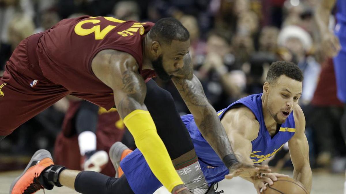 LeBron James (der.) y Stephen Curry batallan por la pelota en un partido entre los Cavaliers y los Warriors el 25 de diciembre del 2016.