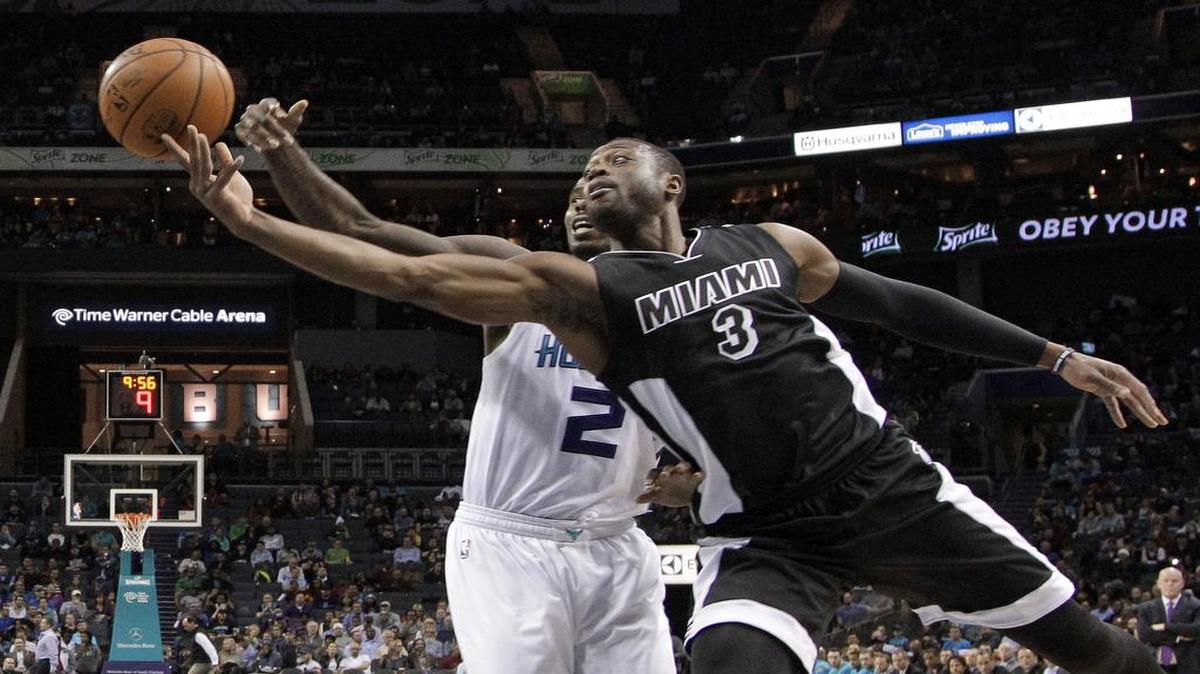 Dwyane Wade (#3) trata de pasar la bola ante la marca de Marvin Williams, de los Hornets, en el partido efectuado el 9 de diciembre del 2015 en Charlotte.