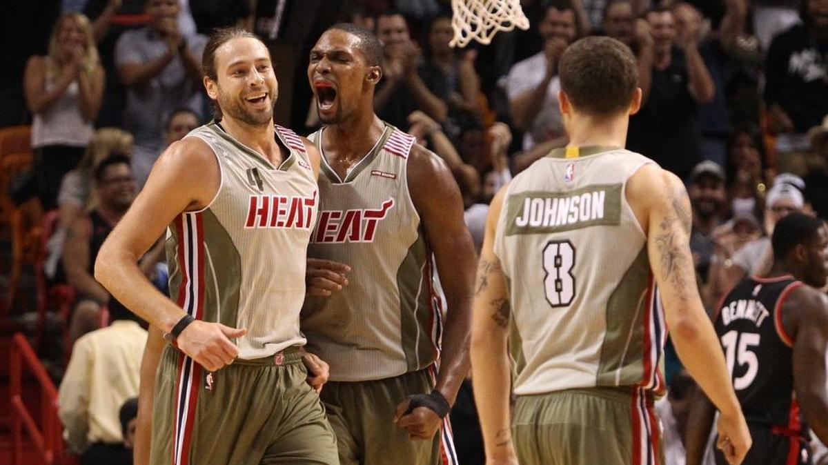 Chris Bosh (centro) y Josh McRoberts, del Heat, celebran una jugada de McRoberts en el cuarto periodo del triunfo sobre los Raptors, el domingo 8 de noviembre del 2015 en el AmericanAirlines Arena en Miami.