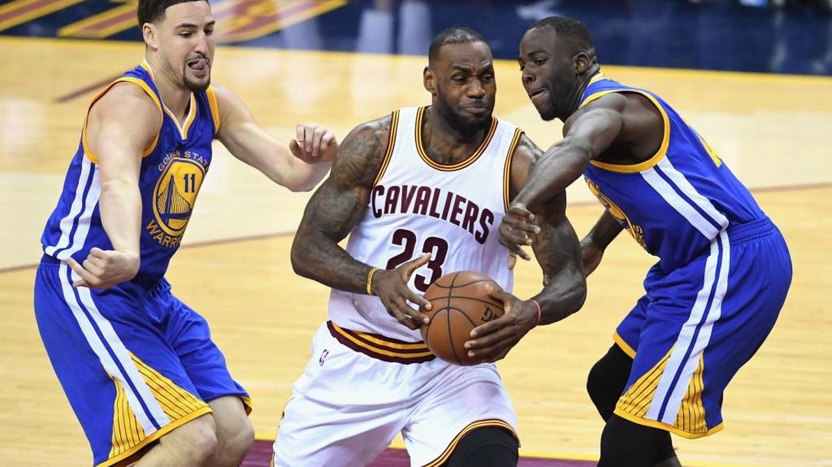 Draymond Green (der.) y Klay Thompson (izq.), de los Warriors, marcan a presión al jugador de los Cavaliers LeBron James, el 8 de junio en el Juego 3 en Cleveland.