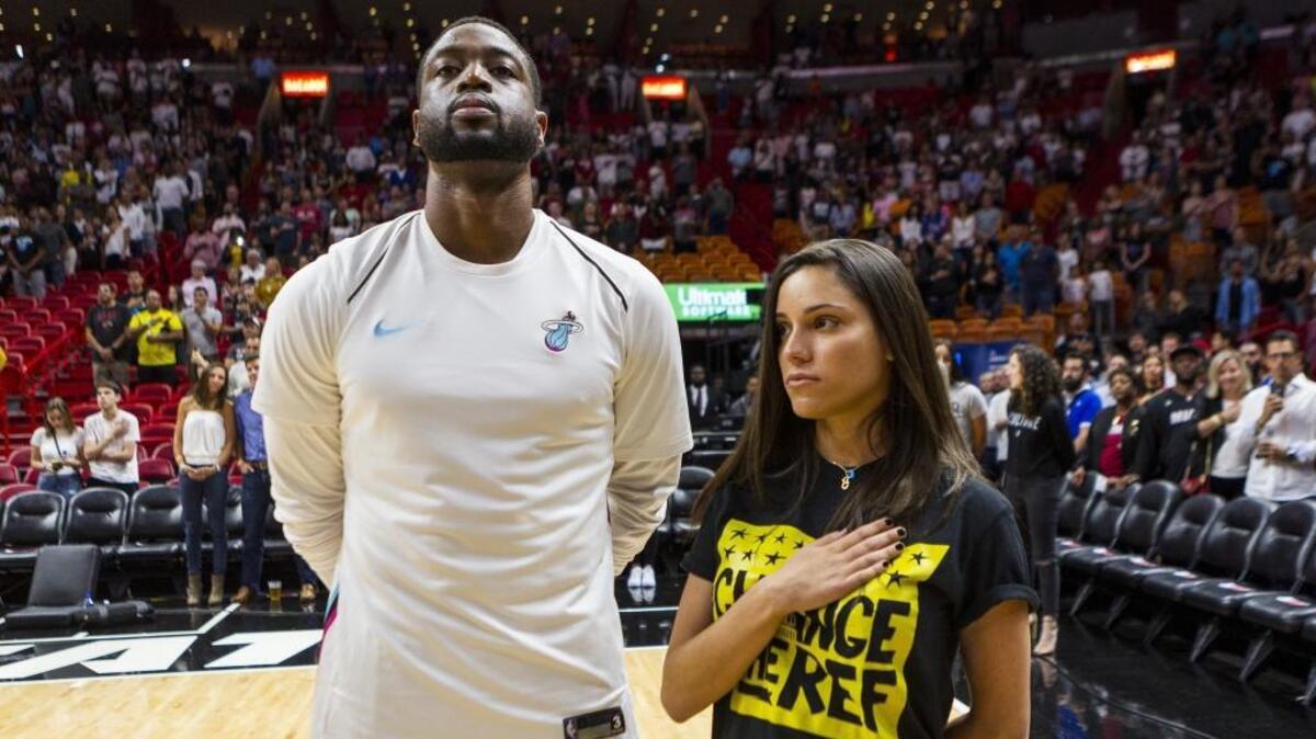 Dwyane Wade y Andrea Ghersi, hermana del joven venezolano Joaquín Oliver que falleció en el tiroteo en la escuela Marjory Stoneman Douglas en Parkland, Florida, durante la ceremonia del himno de Estados Unidos antes del partido entre el Heat y los Pistons, el 3 de marzo de 2018 en Miami.
